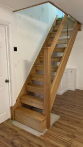 Photo of a staircase replacement in a Southampton home. Glass and Oak open riser staircase letting in light and air